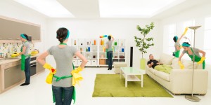 same woman cleaning living room while man rests on sofa, digital composite image